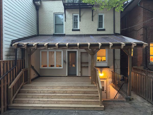 New pressure-treated wood deck with polycarbonate roof in Downtown Toronto